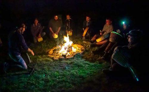 un groupe de personnes autour d'un feu lors de la nuit perchée