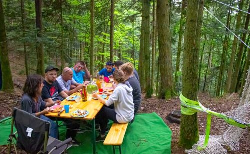 une groupe de personne assis à une table en pleine forêt