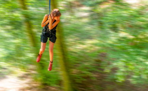femme qui se balance avec une corde en pendule dans un atelier grimpe d'arbres