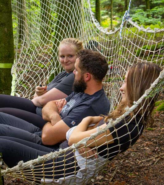 trois personnes assises dans un hamac - grimpe d'arbres